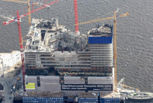 HAMBURG, GERMANY - APRIL 24: This aerial view shows the construction of the new Philharmonic Hall (Elbphilharmonie) at the Hanseatic city of Hamburg on April 24, 2010 in Hamburg, Germany. The Hamburg Philharmonic Hall (Elbphilharmonie) is a concert hall under construction in the HafenCity quarter of Hamburg, Germany. The concert hall is designed on top of an old warehouse. It will be the highest building of Hamburg. The Elbphilharmonie is the city of Hamburg's most prized, current architectural project, though it is also threatening to become an embarrassment as construction costs are reportedly rising by up to 200 percent and completion is likely to be delayed to 2012, two years behind schedule. (Photo by Andreas Rentz/Getty Images)